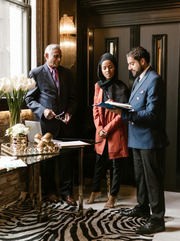 Professionals discussing in an elegant hotel lobby with luxurious interior design and decor.